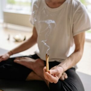 A person holding burning Palo Santo, focusing on relaxation and spiritual wellness.